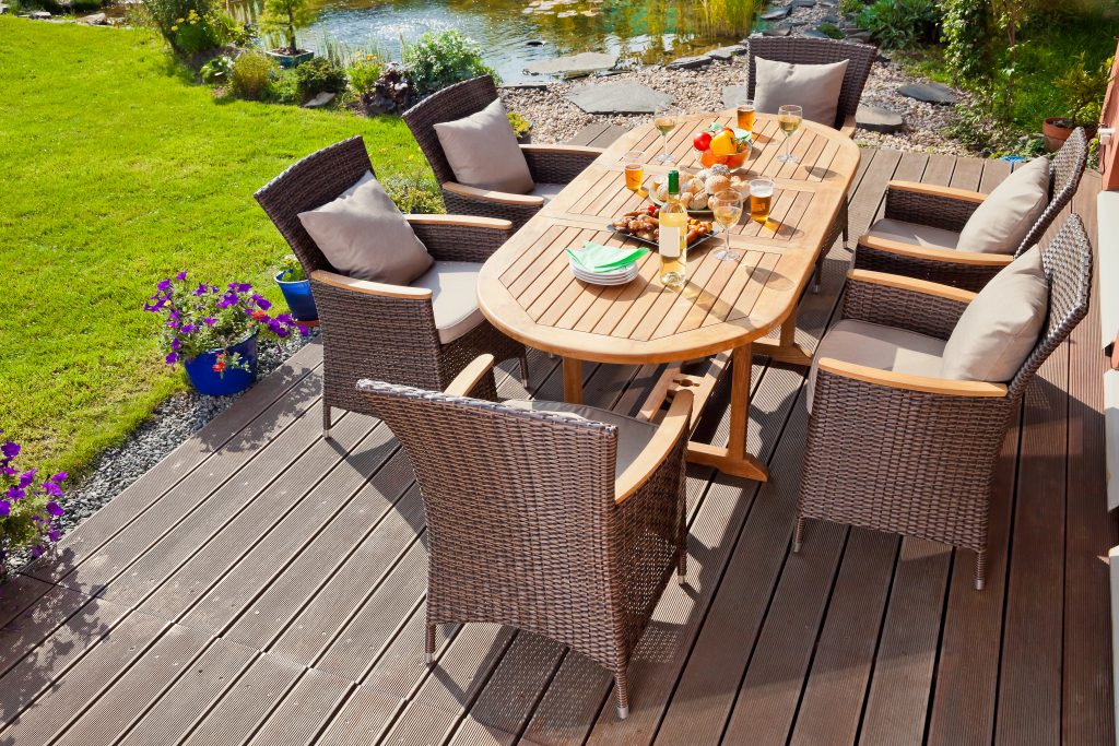 ratanové zahradní stoličky okolo dřevěného stolu na terase