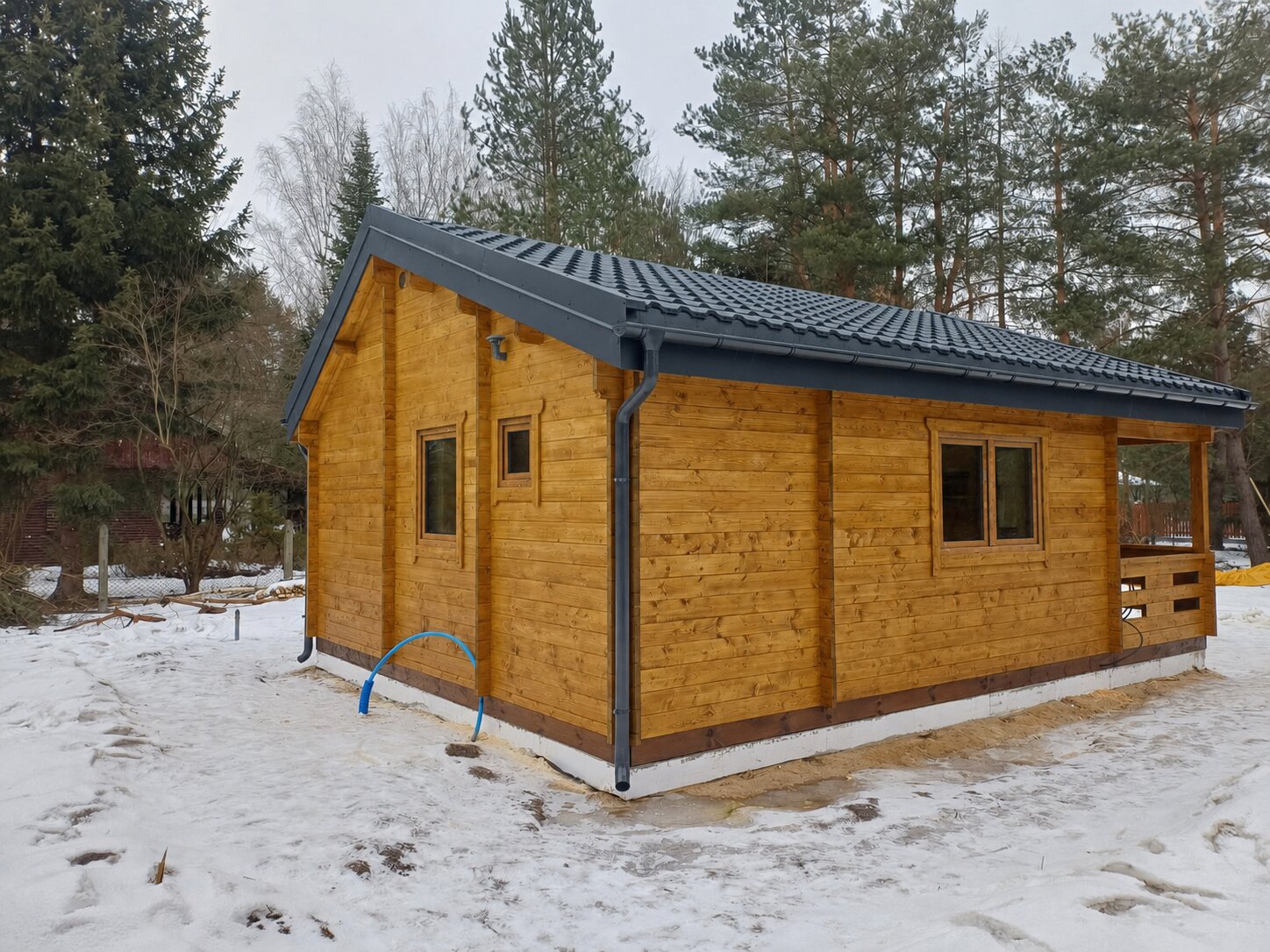 Vytápění dřevěné chaty v zimě: zahradní domek SANTIAGO III z naší realizace na zasněženém pozemku u lesa