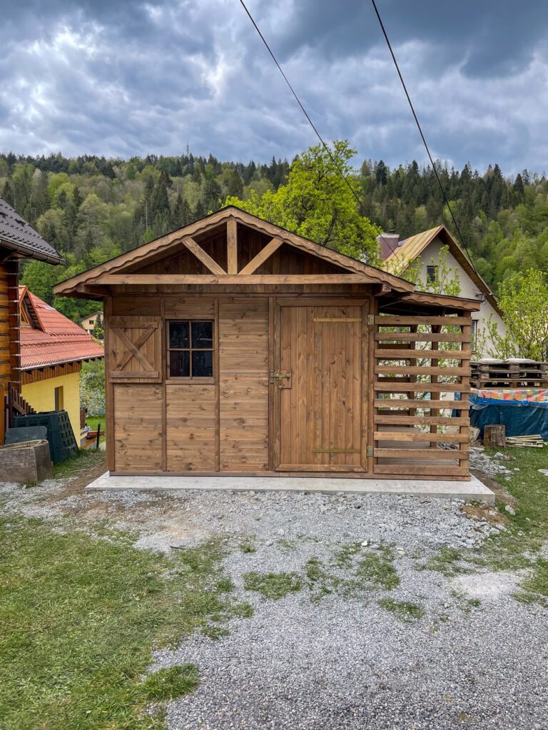 Dřevěný zahradní domek BESKYDEK – čelní pohled na hnědý domek s přístřeškem na dřevo
